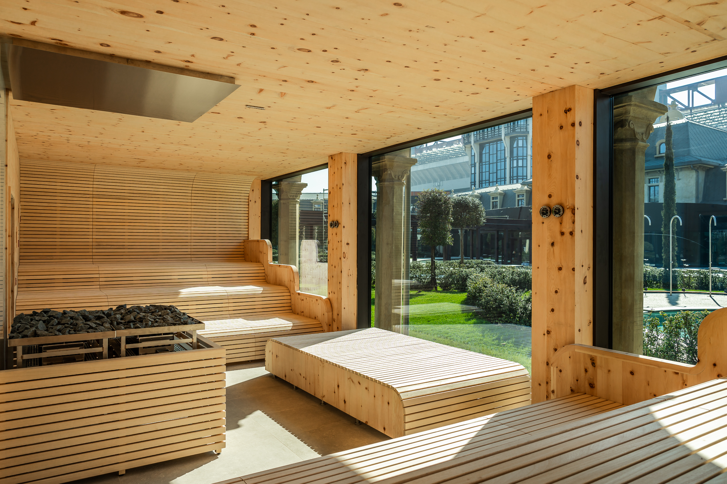 Moderna sauna in legno con ampie vetrate che si affacciano sul giardino. Un'esperienza benessere perfetta in una day spa.