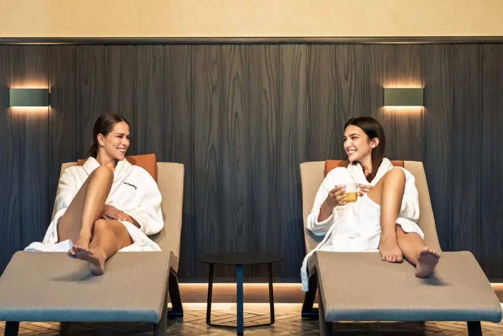 Due donne si rilassano in accappatoio al De Montel, sorseggiando un tè.