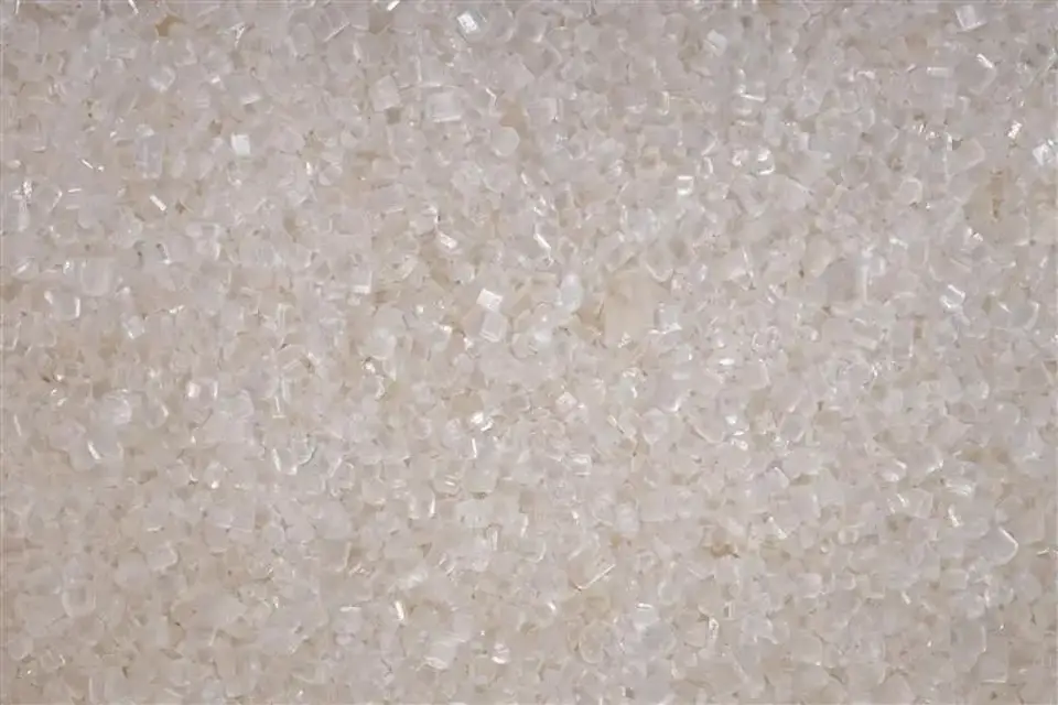 Vista ravvicinata di cristalli di zucchero bianco scintillanti.