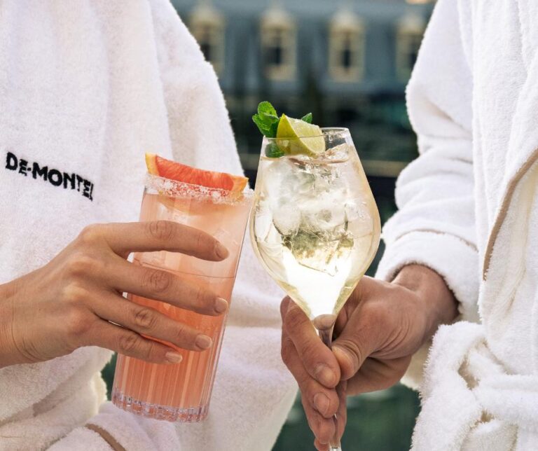 Coppia in accappatoio che sorseggia cocktail: pompelmo e spumante. De Montel.