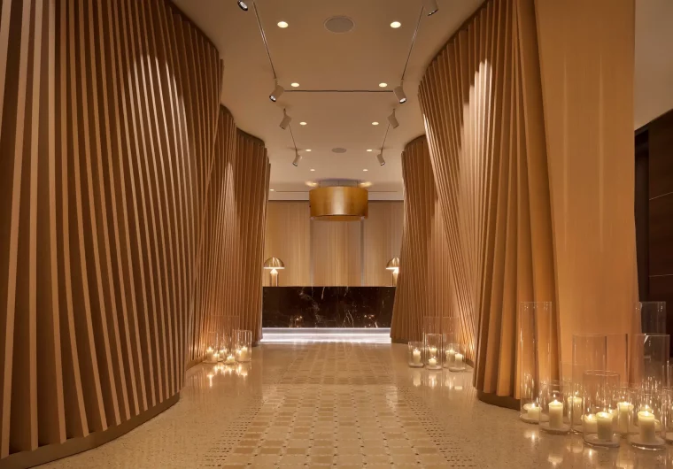 Ingresso moderno con pareti in legno scanalato e candele luminose