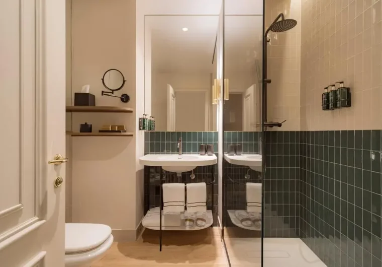 Bagno moderno di hotel con doccia a pioggia e lavabo sospeso