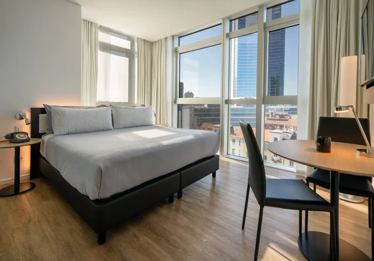 Camera da letto moderna con vista sulla città, letto king-size e scrivania