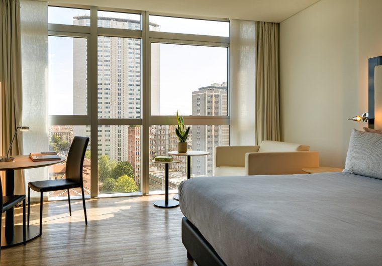 Camera da letto moderna con vista panoramica sulla città e scrivania per lavorare