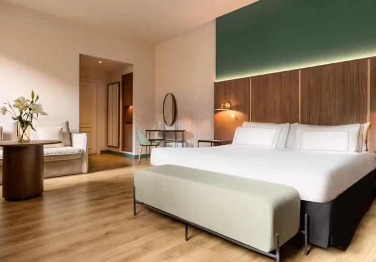 Interno di una suite d'albergo moderna con letto king-size e zona salotto