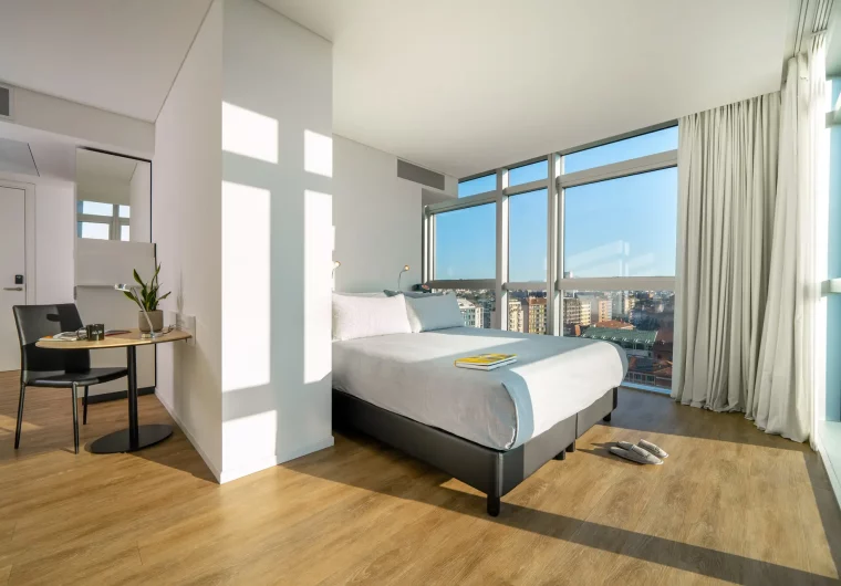 Camera da letto moderna con letto matrimoniale e vista panoramica sulla città