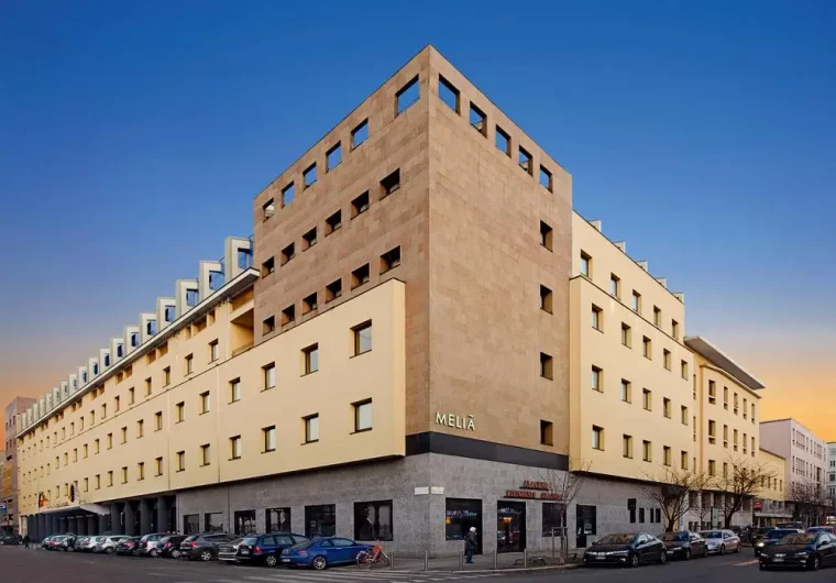 Hotel Melia con facciata gialla e dettagli in pietra, sotto un cielo blu.