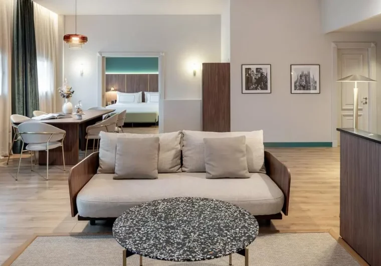 Soggiorno e camera da letto in hotel partner con divano beige