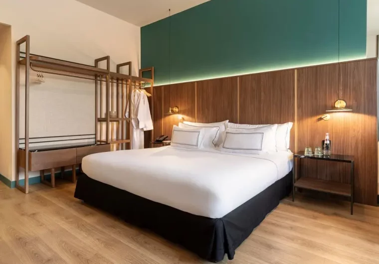 Interno di una camera d'albergo moderna con letto king-size e arredi in legno